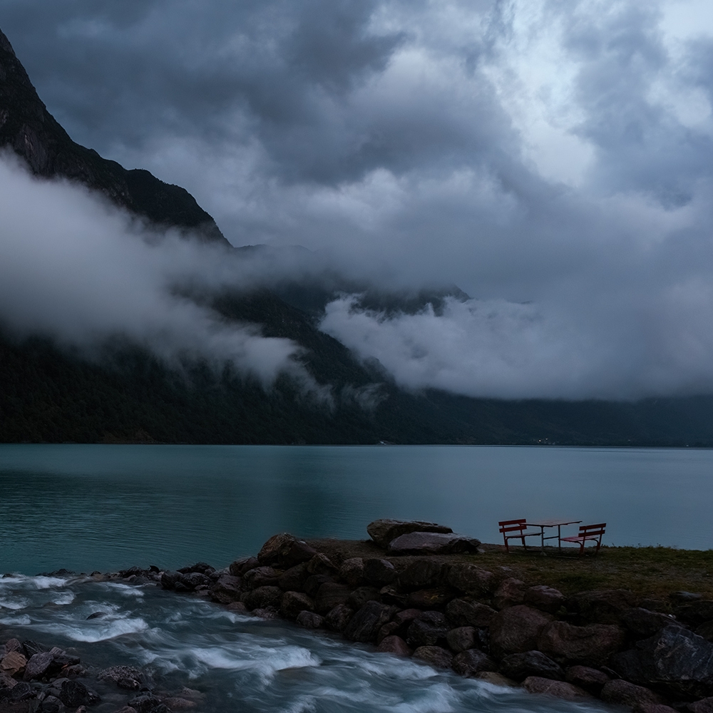 Een picknicktafel, 's avonds laat, met lage wolken boven het Oldevatnet, Noorwegen.